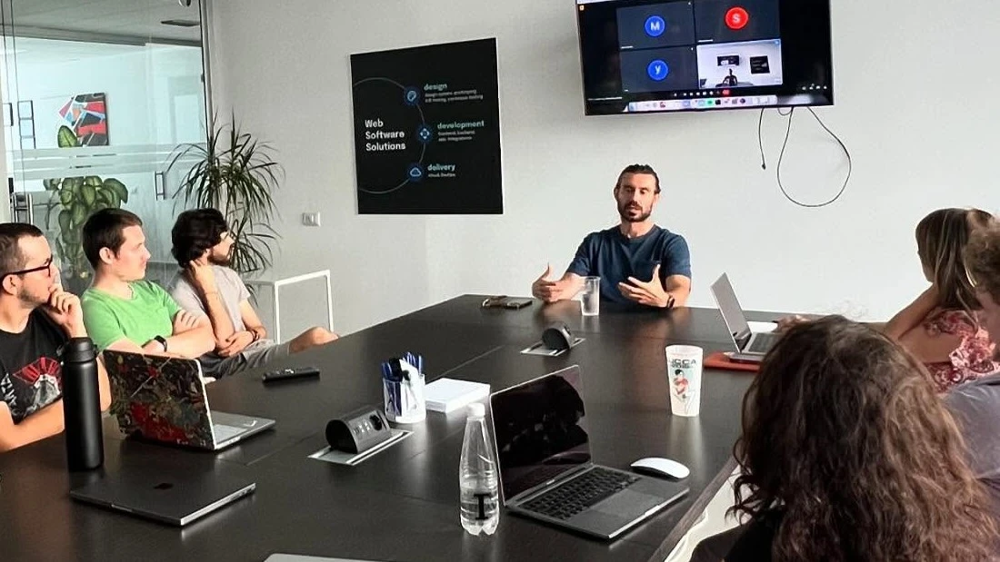 The dotenv team around the meeting-room table, while one of us talks through a project